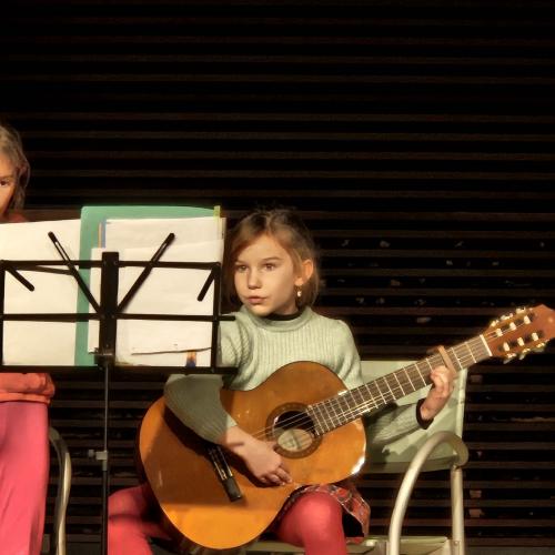 Zwei Mädchen musizieren an der Gitarre und an der Flöte