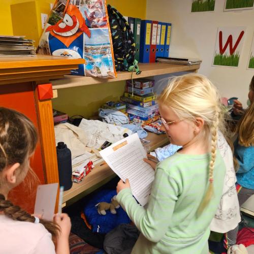 Kinder suchen in der Klasse nach Hinweisen