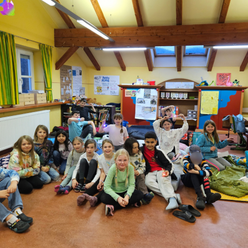 Klassenfoto. Kinder sitzen in einem Klassenzimmer auf dem Boden