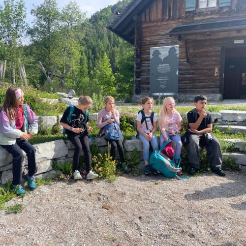 Kinder sitzen auf einer Steinbank