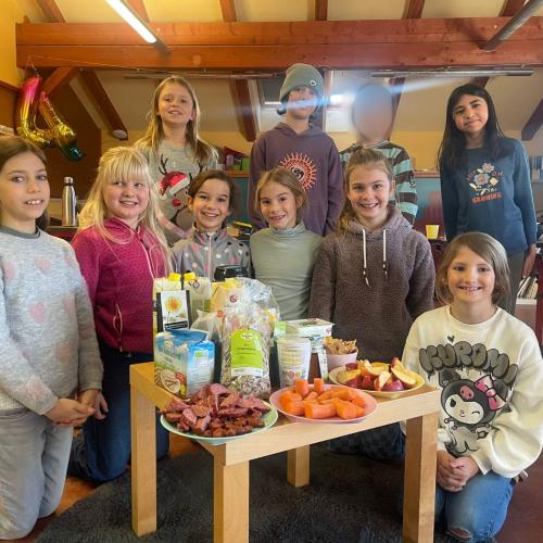 Kinder der 4.Klasse gemeinsam auf dem Bild mit dem Frühstückstisch