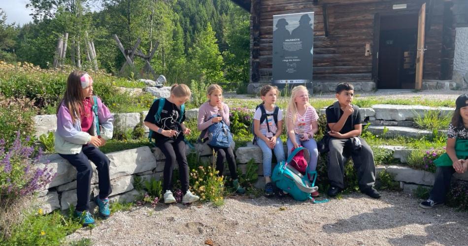 Kinder sitzen auf einer Steinbank
